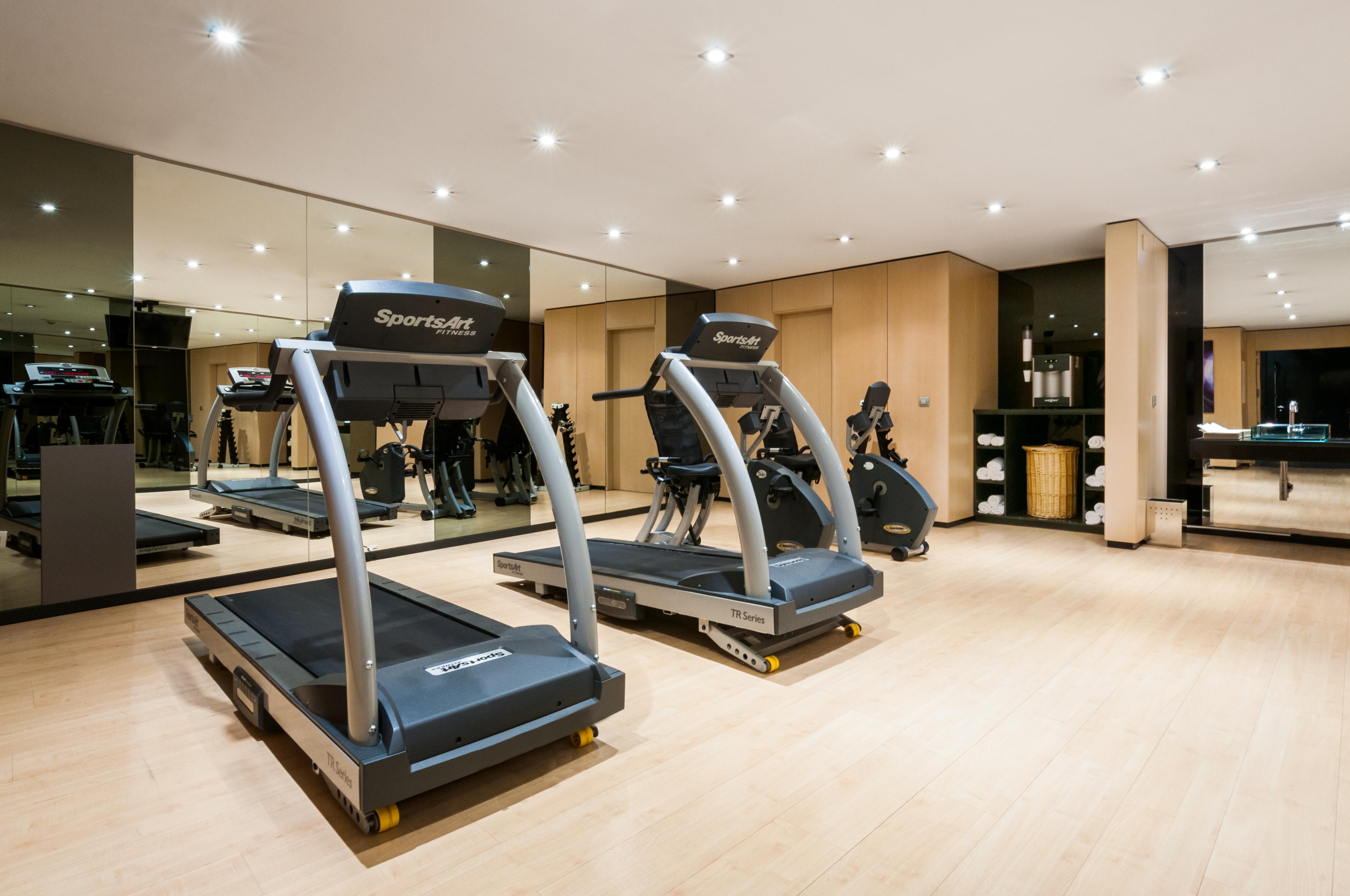 Eurostars Palace Cordoba Ngoại thất bức ảnh The photo shows a modern gym or fitness area featuring two treadmills. The equipment is well-maintained and positioned on a light wooden floor. There are mirrors on the wall reflecting the workout area, which adds to the spacious feel. The overall se